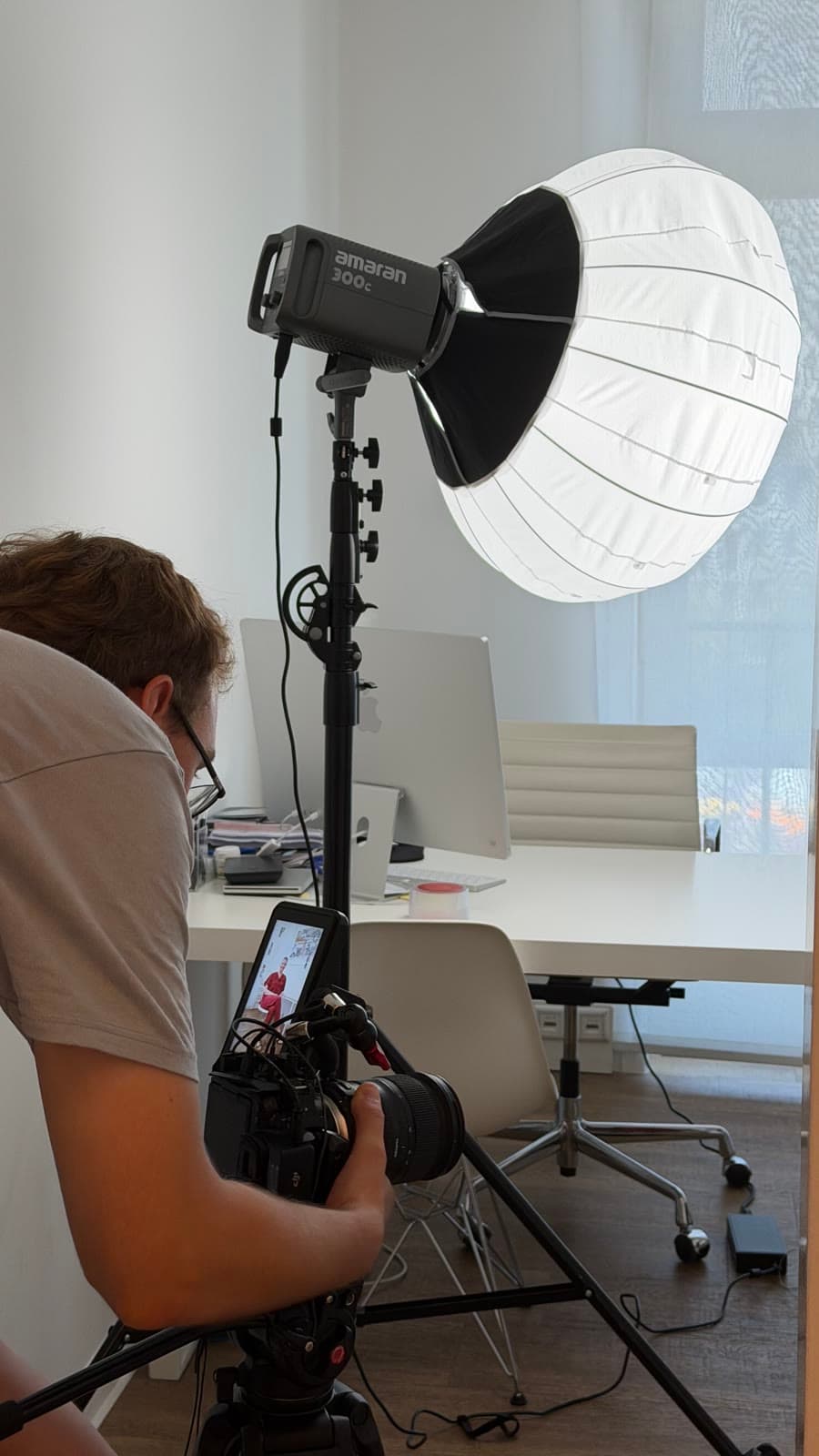 Tim dreht mit Kamera, daneben eine große Softbox